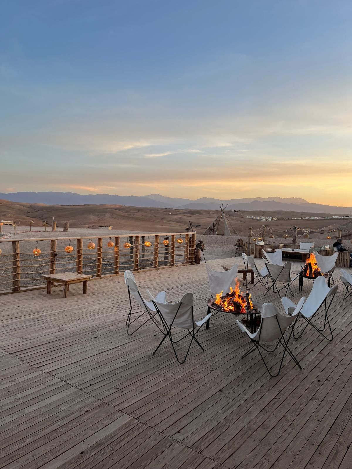 Terrasse à braseros au camp Al Kamar dans le désert d'Agafay au crépuscule